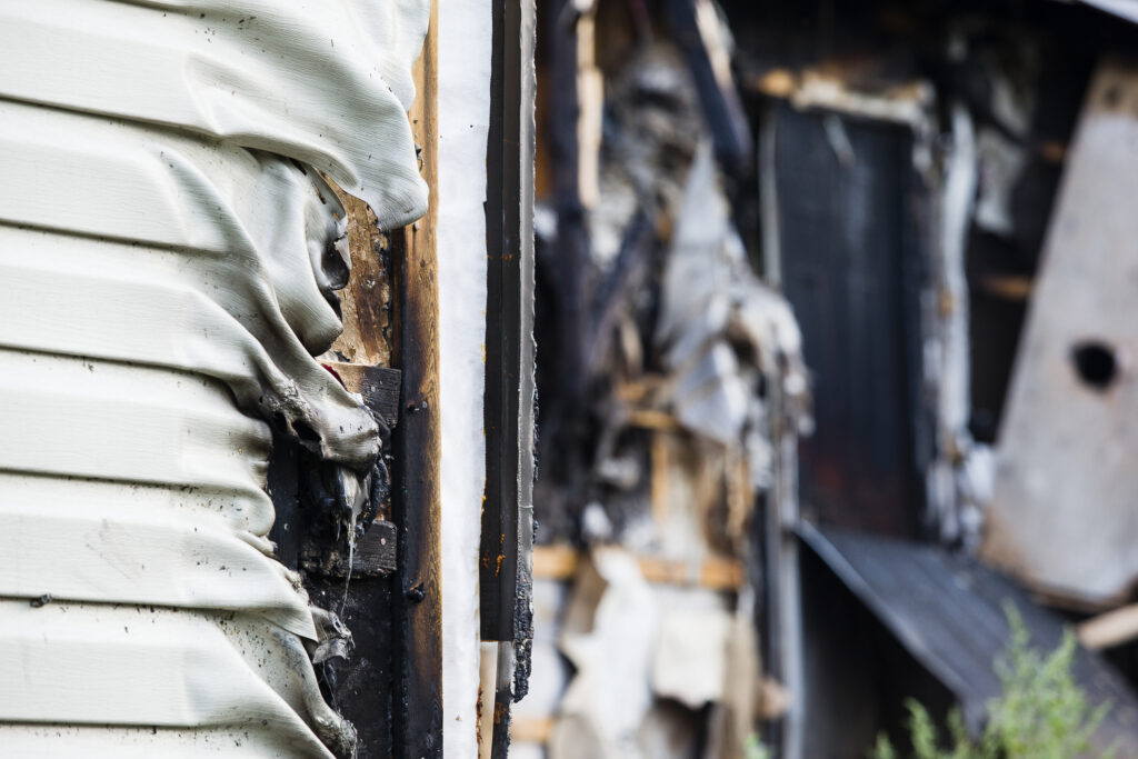 A close-up photograph of a wall on the exterior of a house damaged by fire in Northglenn, CO